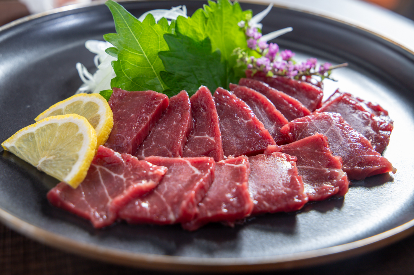 大葉やレモンを添えた馬刺しの盛り合わせ